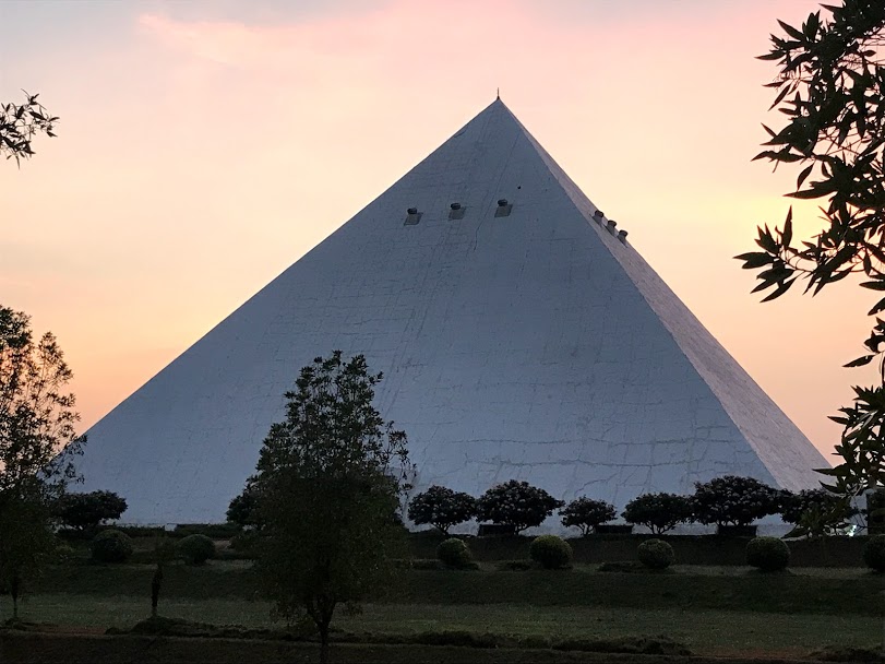 Meditation pyramid at dusk among trees