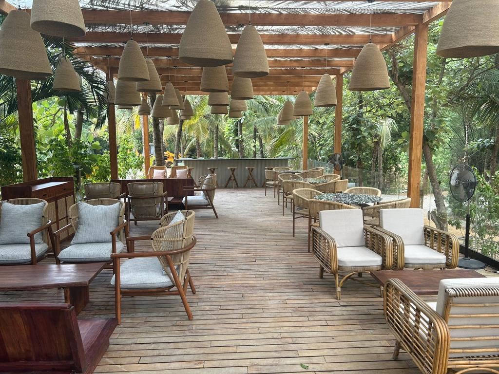 Thatched-roof open sit-out with woven pendant lights and lounge seating