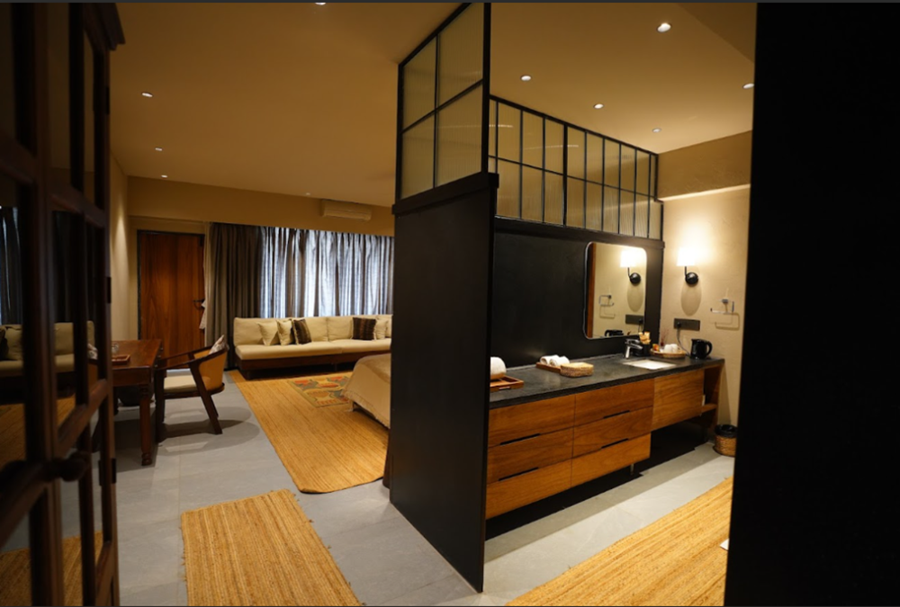 Suite interior with wooden vanity, living area, and glass room divider