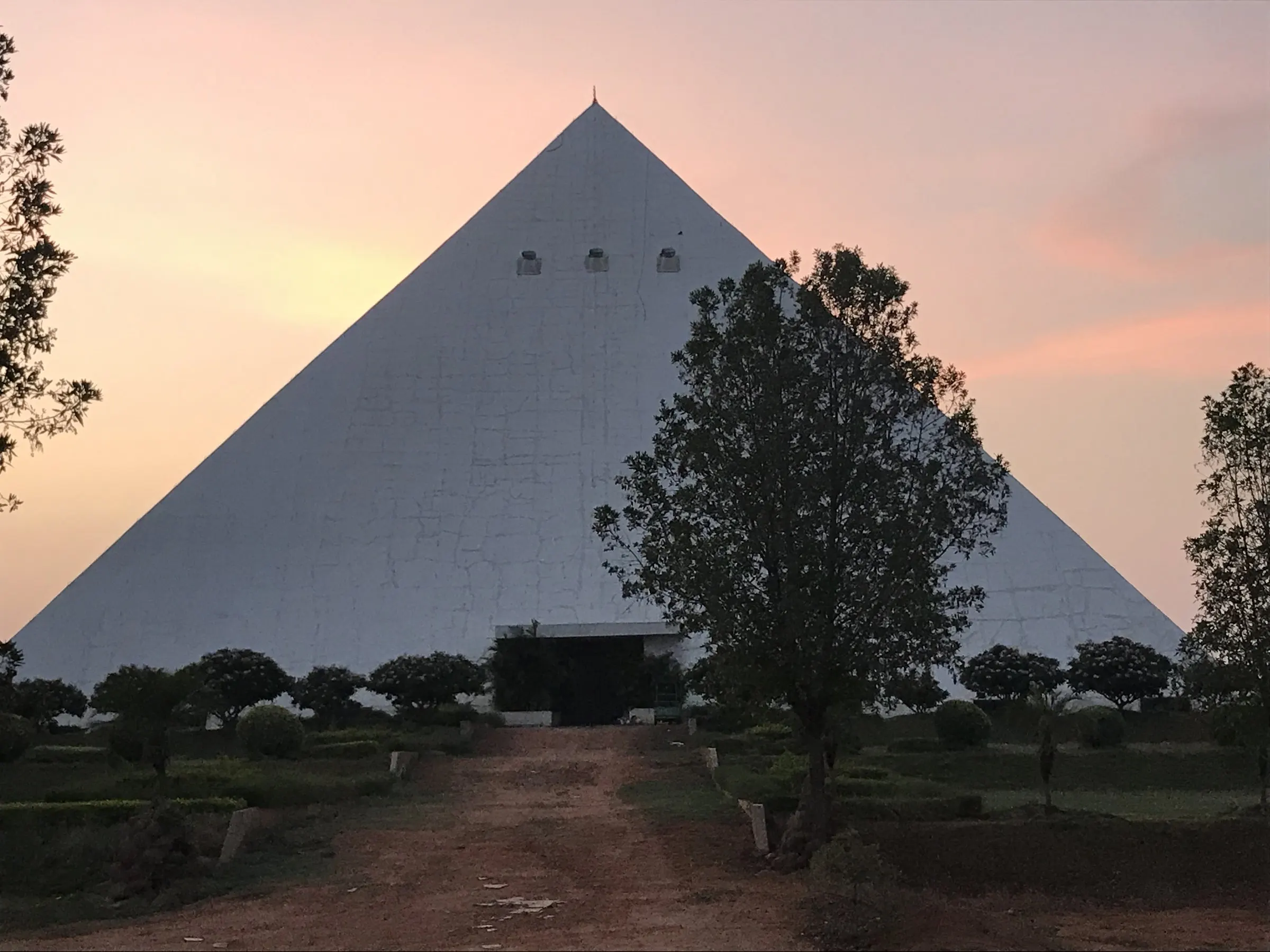 The white meditation pyramid against a rose-coloured sky