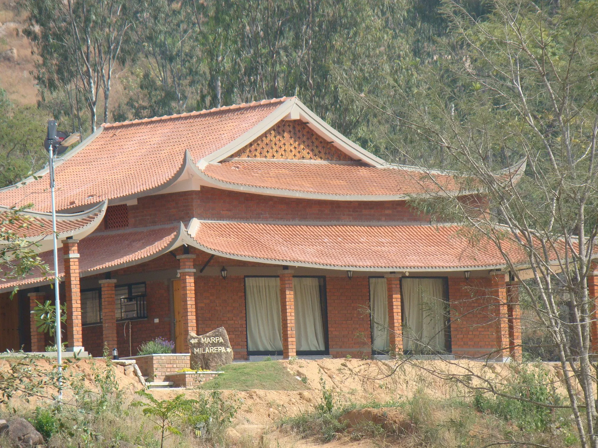 Layered terracotta roofs and brick piers of a cottage