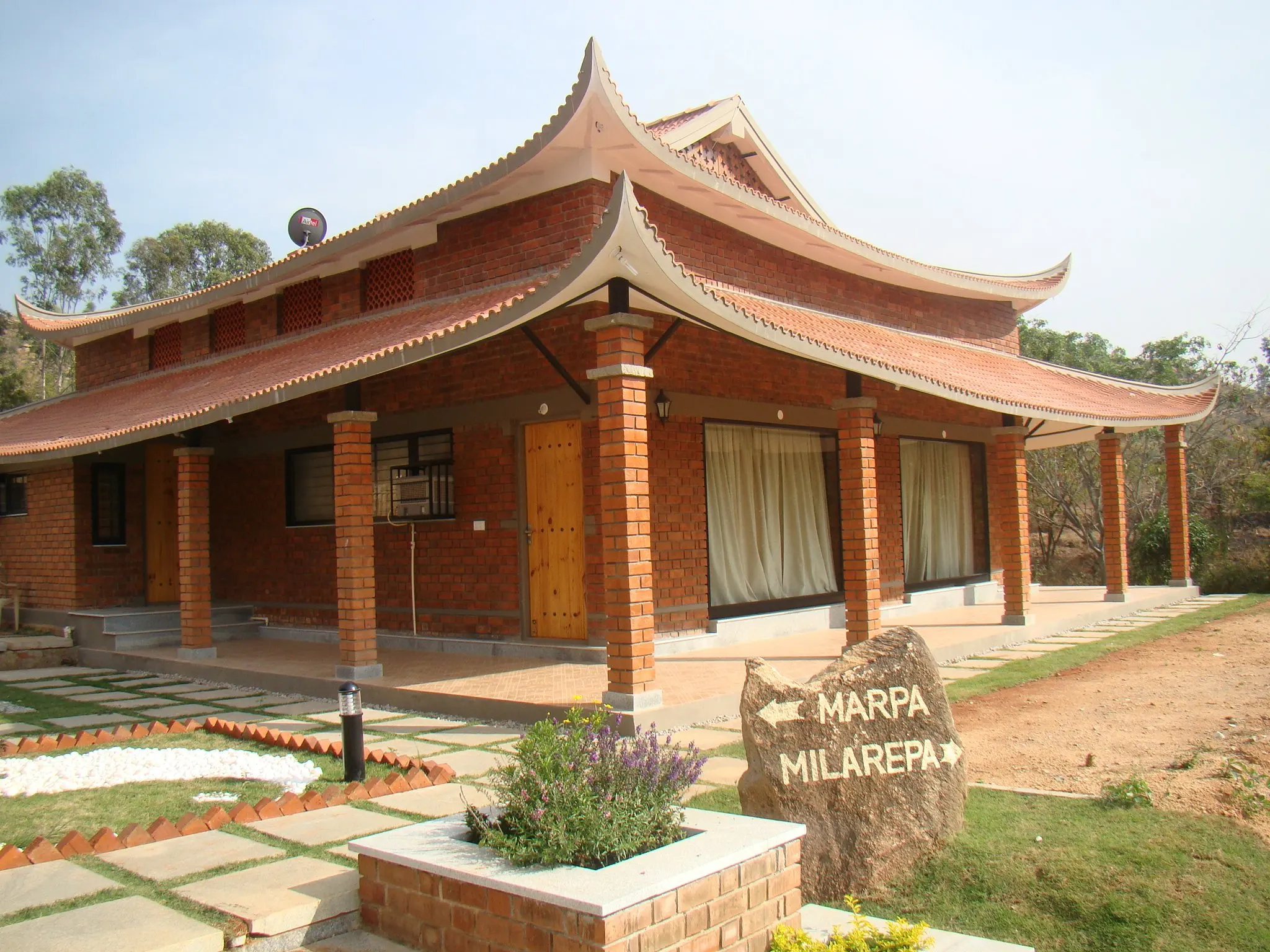 Brick pagoda cottages and stepping-stone paths, with a carved stone cottage sign