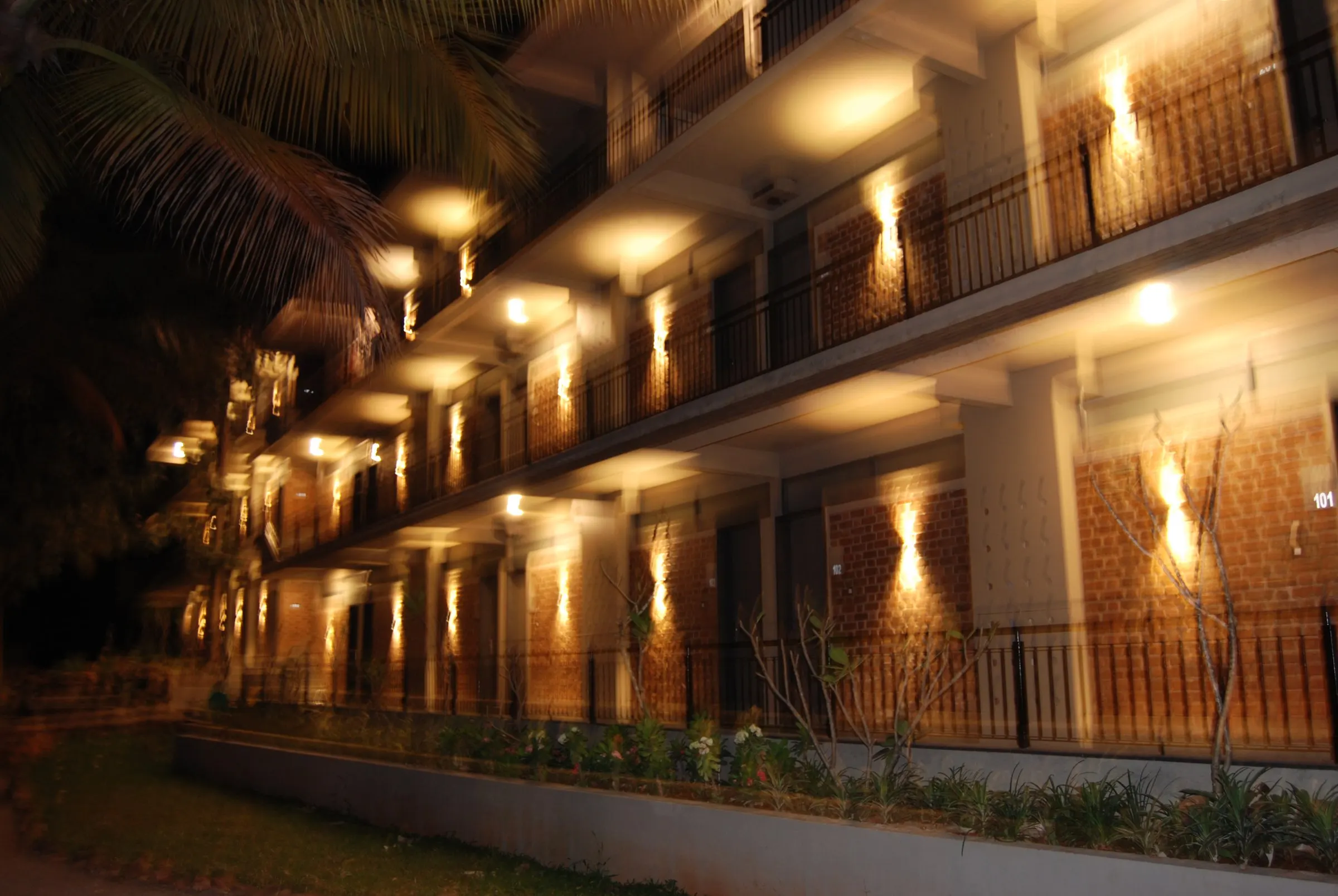 Warm wall lights along the brick balconies of the Starlight block at night